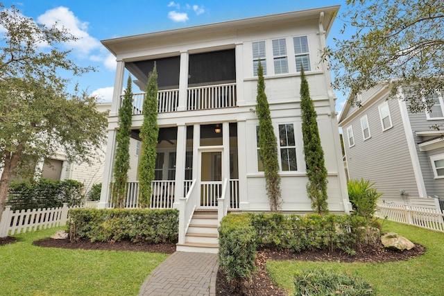 view of front of home with a front yard, a sunroom, and fence