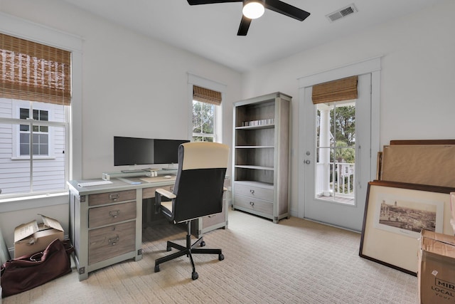 office featuring light carpet, ceiling fan, and visible vents