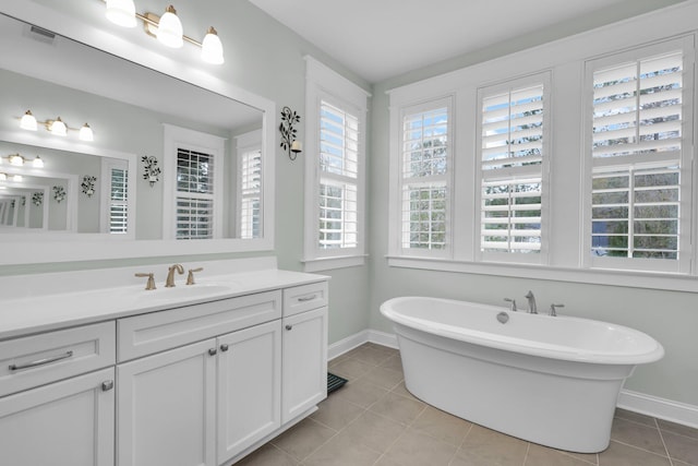 full bathroom with visible vents, a freestanding bath, vanity, tile patterned flooring, and baseboards