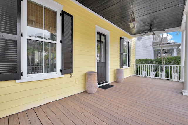 wooden deck featuring covered porch and a ceiling fan