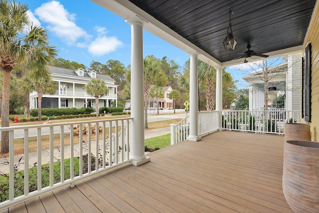 wooden terrace with covered porch, a residential view, and a ceiling fan