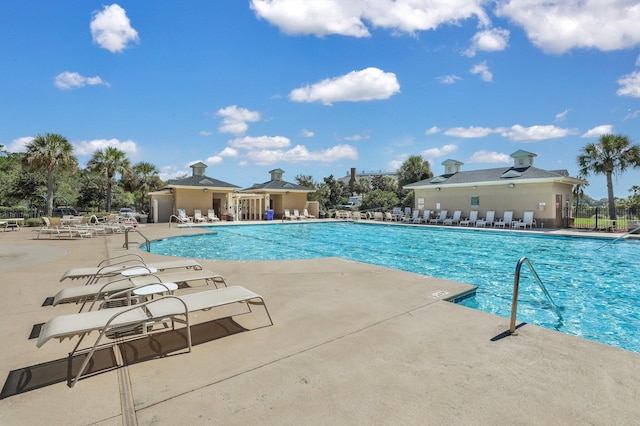 community pool with a patio and fence