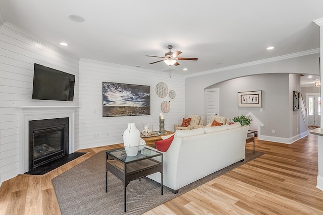 living room with ceiling fan, light hardwood / wood-style flooring, and ornamental molding