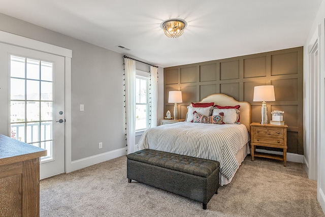 bedroom featuring multiple windows, light colored carpet, and access to exterior