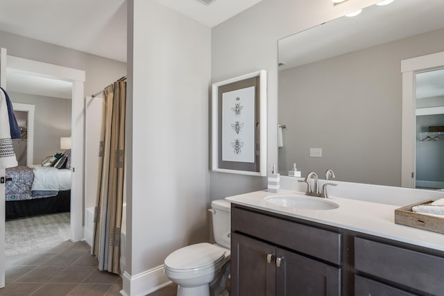 bathroom featuring tile flooring, toilet, and large vanity