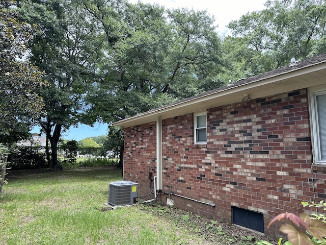 view of home's exterior with central AC unit and a yard