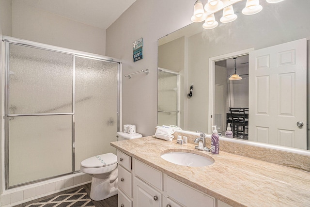 bathroom featuring walk in shower, vanity, and toilet