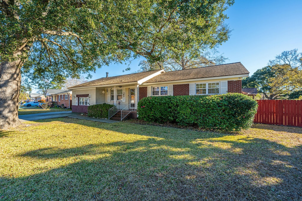 single story home with a front lawn and covered porch