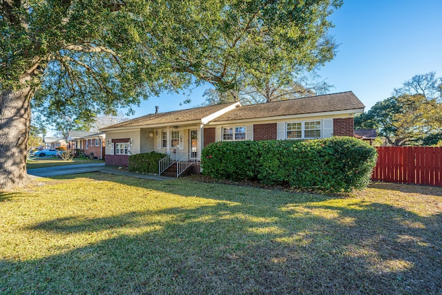 single story home with a front lawn and covered porch