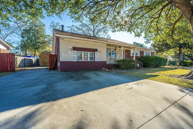 ranch-style home with a front yard and a shed