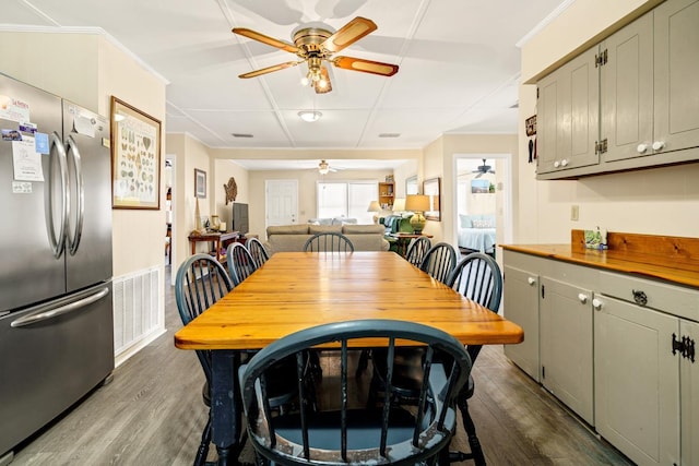 dining room with ceiling fan, crown molding, and dark hardwood / wood-style flooring