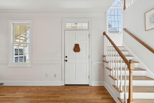 entryway featuring hardwood / wood-style flooring and ornamental molding