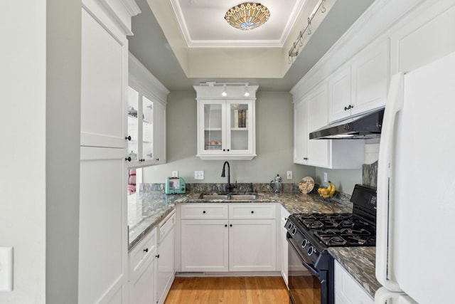 kitchen with white cabinetry, sink, white appliances, and dark stone counters