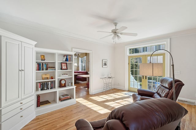 living area with ceiling fan, ornamental molding, and light hardwood / wood-style flooring