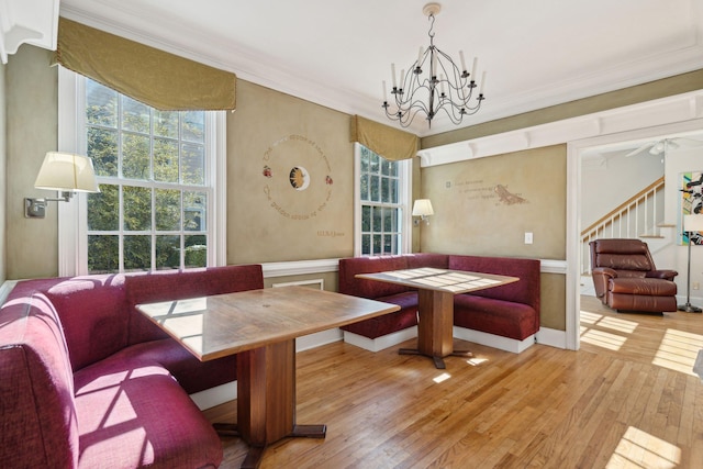 dining area featuring ornamental molding, breakfast area, an inviting chandelier, and light hardwood / wood-style flooring