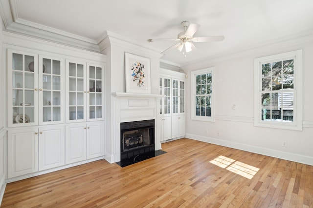 unfurnished living room featuring ornamental molding, ceiling fan, and light wood-type flooring