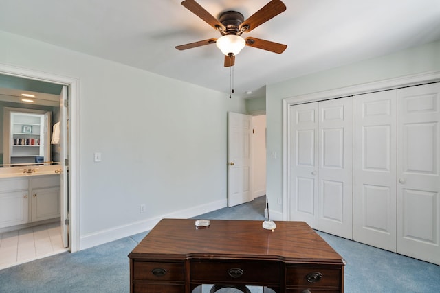 unfurnished office with ceiling fan and light carpet