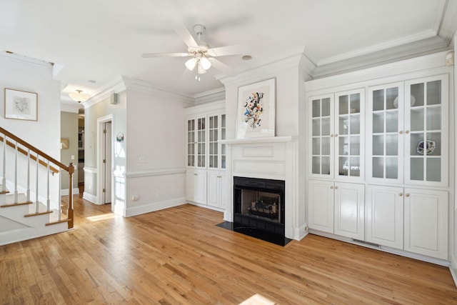 unfurnished living room with crown molding, ceiling fan, and light hardwood / wood-style flooring