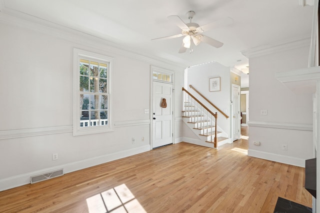 foyer with ornamental molding, ceiling fan, and light wood-type flooring