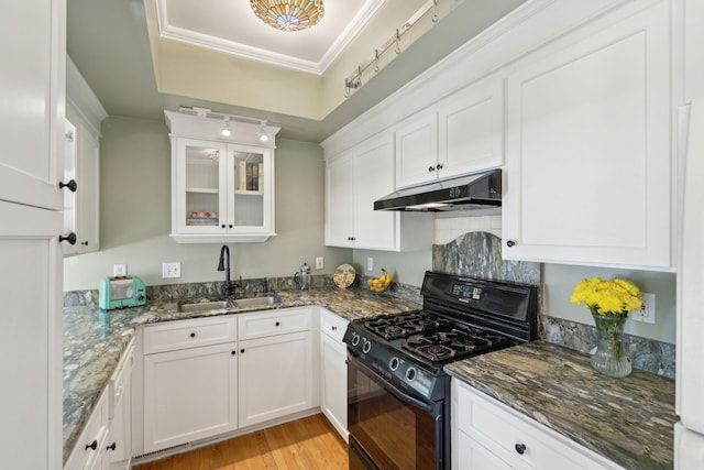 kitchen with white cabinetry, sink, dark stone counters, crown molding, and black range with gas cooktop