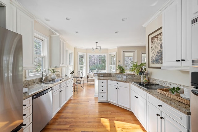 kitchen featuring a sink, light wood-style flooring, white cabinets, and stainless steel appliances
