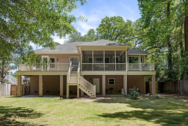 rear view of house with stairs, a fenced backyard, a yard, and a shingled roof