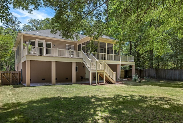 rear view of house featuring stairs, a sunroom, a fenced backyard, a patio, and a yard