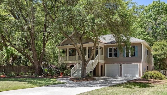 view of front of home featuring a porch, driveway, a garage, stairway, and fence
