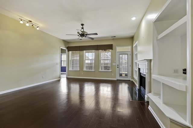 unfurnished living room with dark hardwood / wood-style flooring and ceiling fan