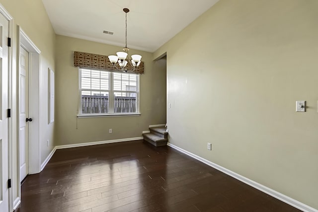 unfurnished dining area featuring a notable chandelier and dark hardwood / wood-style flooring