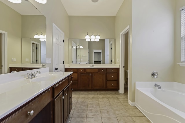 bathroom featuring vanity, a tub, tile patterned floors, and toilet