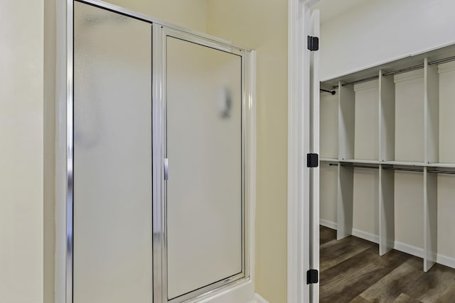 bathroom with wood-type flooring and an enclosed shower