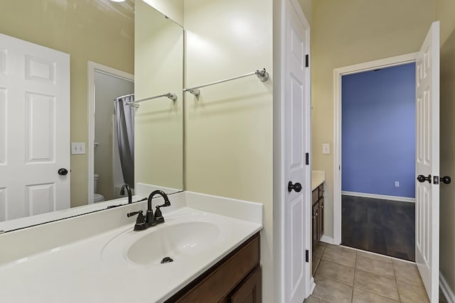 bathroom with vanity, toilet, and tile patterned flooring