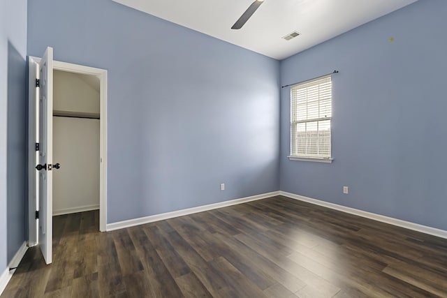 unfurnished room featuring dark wood-type flooring and ceiling fan