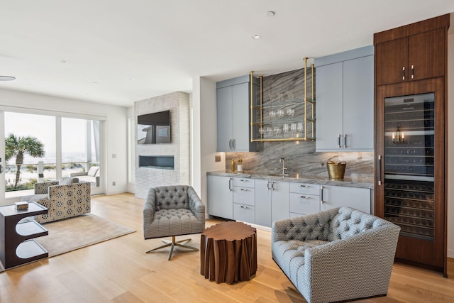 interior space featuring wine cooler, indoor wet bar, and light hardwood / wood-style flooring