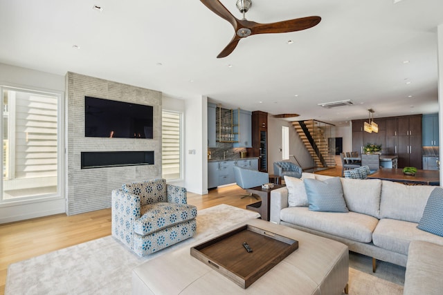 living room with light hardwood / wood-style flooring and ceiling fan