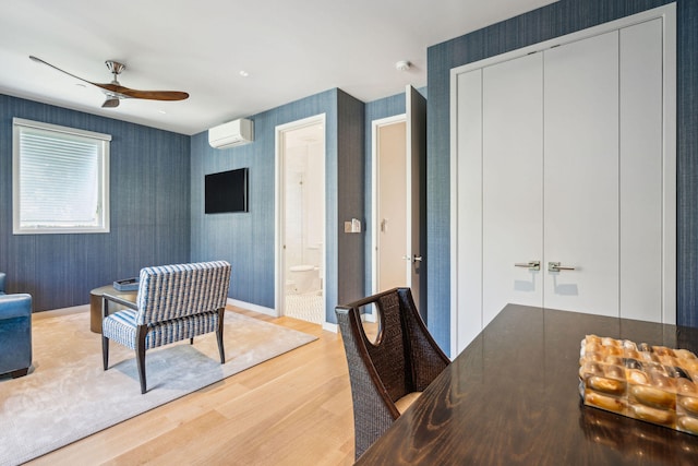 office with hardwood / wood-style flooring, ceiling fan, and a wall mounted air conditioner