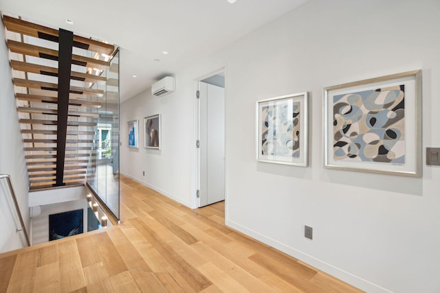 hall featuring a wall unit AC and light hardwood / wood-style flooring