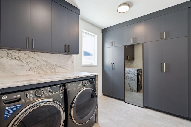 washroom featuring cabinets and separate washer and dryer