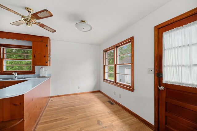 2708 Mawood Ave, North Charleston, SC 29406 - kitchen featuring light wood-style flooring, baseboards, a sink, light countertops, and a ceiling fan