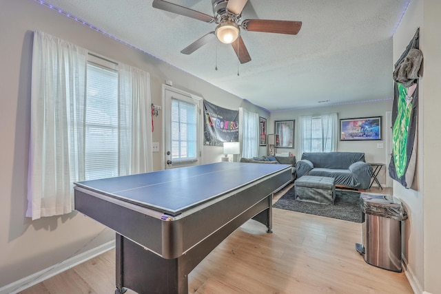 rec room featuring a textured ceiling, plenty of natural light, and light wood-style flooring