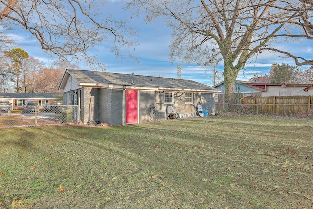 back of property with brick siding, fence, and a yard