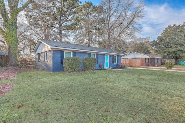 single story home featuring a front yard, brick siding, and fence