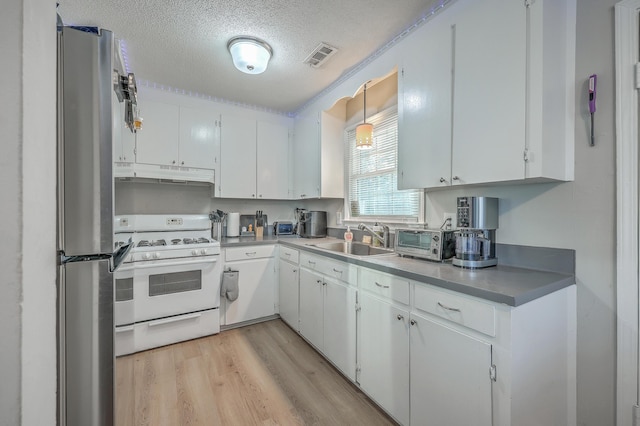 kitchen featuring white cabinetry and white range with gas cooktop