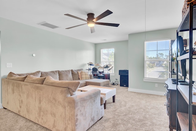 living room featuring a wealth of natural light, ceiling fan, and light colored carpet