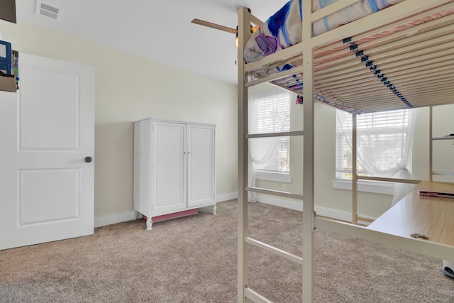 unfurnished bedroom with ceiling fan and light colored carpet