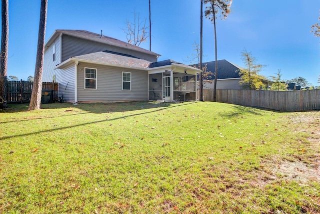 rear view of house with a lawn and a sunroom