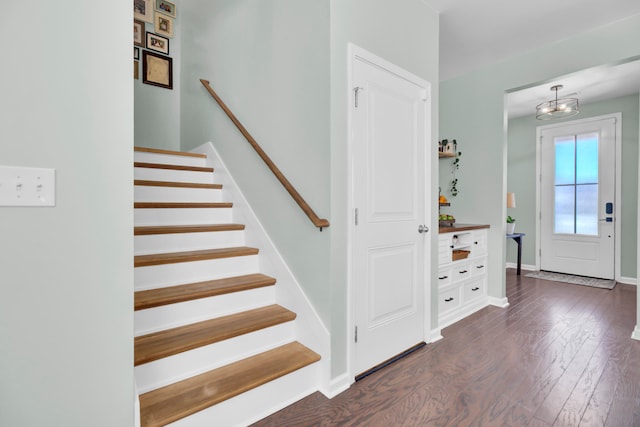 entrance foyer with dark wood-type flooring and an inviting chandelier