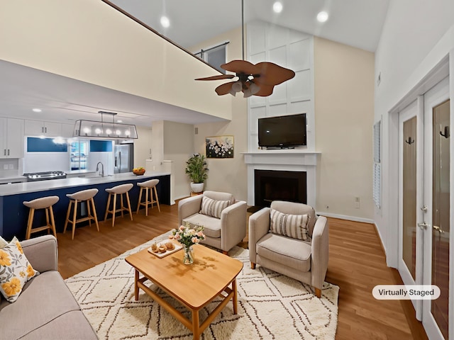 932 Portabella Ln, Charleston, SC 29412 - living area with high vaulted ceiling, light wood-style flooring, a fireplace, a ceiling fan, and baseboards