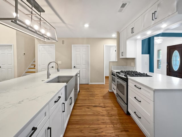 932 Portabella Ln, Charleston, SC 29412 - kitchen featuring stainless steel range with gas cooktop, recessed lighting, a sink, white cabinets, and wood finished floors